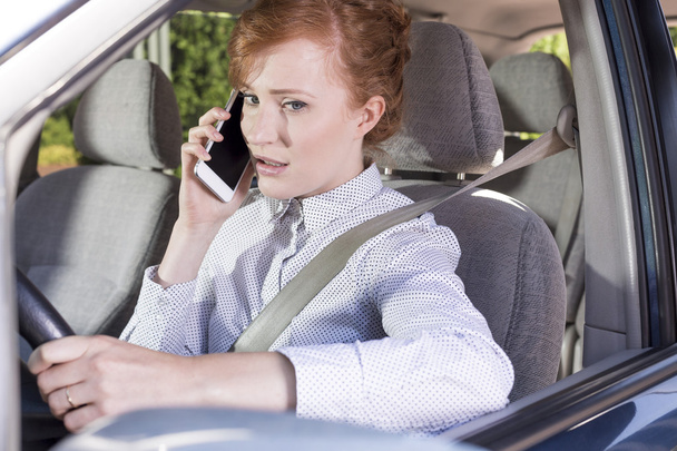 Businesswoman talking on the phone while driving a car - Fotoğraf, Görsel