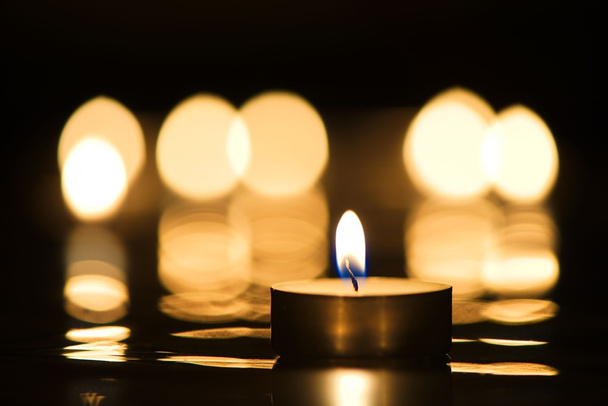 Горящая свеча с отражением свечей
 - Фото, изображение