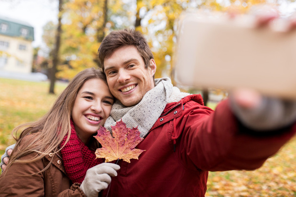 couple taking selfie by smartphone in autumn park - Foto, Imagem