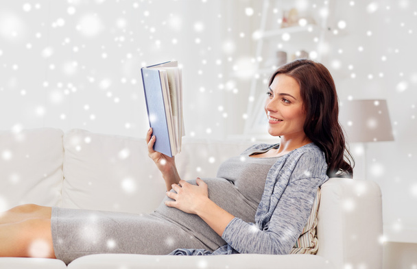 happy pregnant woman reading book at home - Foto, Imagen