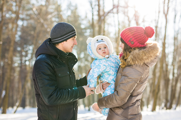 Elternschaft, Mode, Saison und Menschen-Konzept - glückliche Familie mit Baby in Winterkleidung im Freien - Foto, Bild