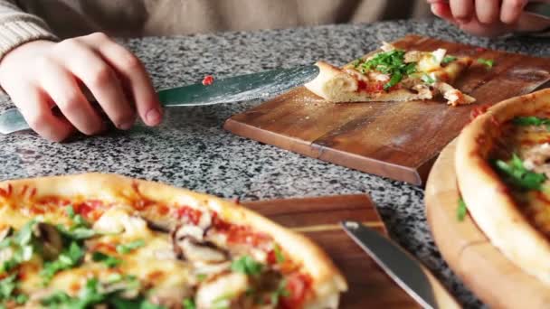 Ihmiset syövät suuria paloja kuumaa pizzaa
 - Materiaali, video