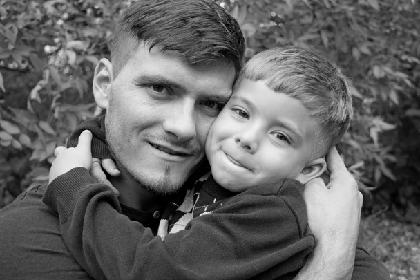 vader houdt zijn zoon in zijn armen, buitenshuis - Foto, afbeelding