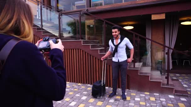 Arab fiatalember üzletember pózol a fénykép gazdaság bőrönd a kezében, háttérben a lépcsőn, étterem. - Felvétel, videó