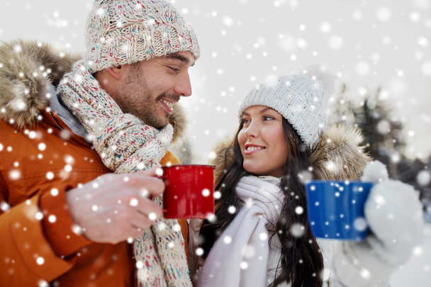 happy couple with tea cups over winter landscape - Fotografie, Obrázek