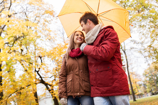 smiling couple with umbrella in autumn park - Fotografie, Obrázek