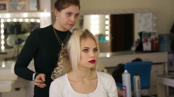 Hairdresser makes hairstyle blonde girl. - Felvétel, videó