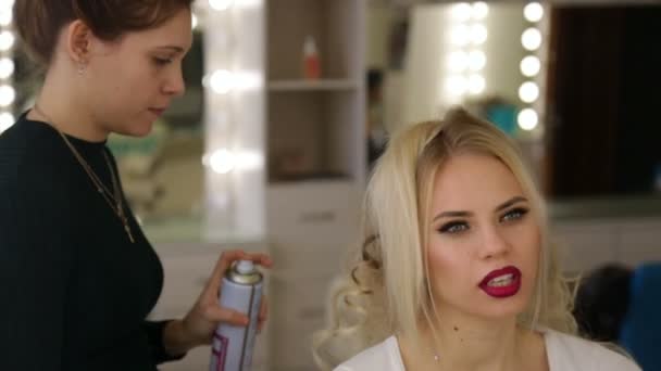 Hairdresser makes hairstyle blonde girl. - Video, Çekim