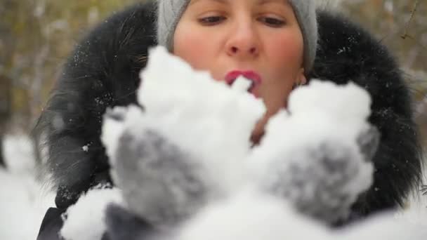 meisje blaast sneeuw met handen close-up in slowmo - Video
