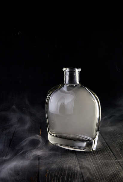 Empty decanter with smoke on black background - Photo, Image