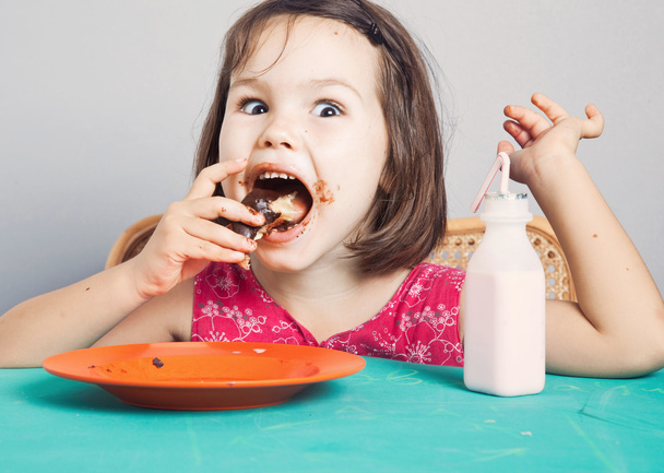 牛乳とドーナツを食べるアジアの女の子 - 写真・画像