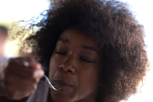 a young African American woman eating pasta - Zdjęcie, obraz