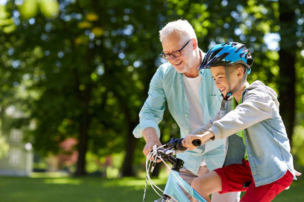 grandfather and boy with bicycle at summer park - Foto, Imagem