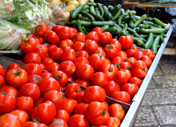 Big red natural organic tomatoes and cucumbers at the farm market - Foto, Bild