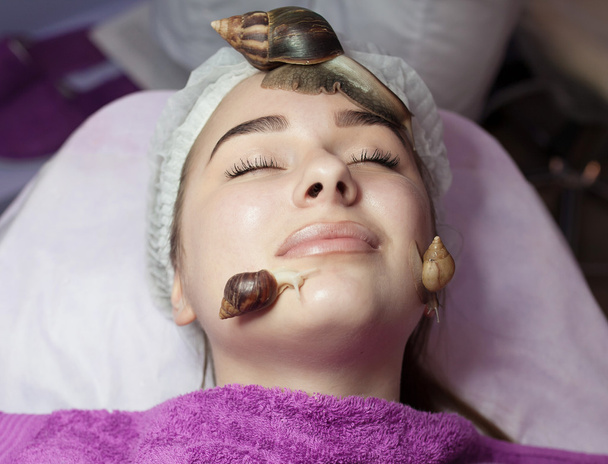 woman getting snail skin cleaning at beauty salon - Photo, Image