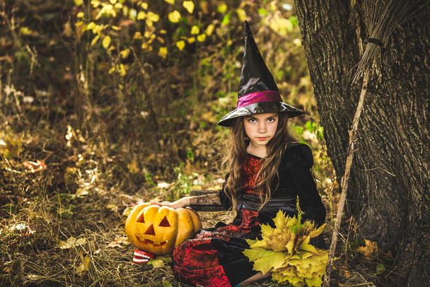 Mutlu Cadılar Bayramı. Elinde balkabağı olan sevimli küçük cadı.. - Fotoğraf, Görsel