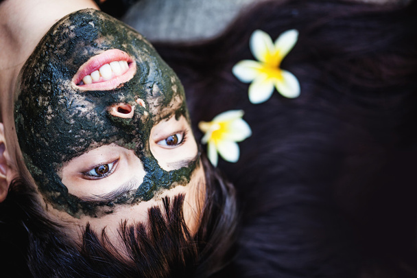 mujer haciendo máscara de arcilla negro
 - Foto, Imagen