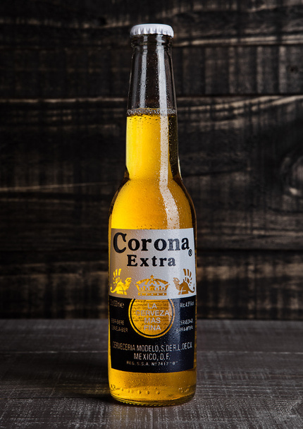 LONDON, UNITED KINGDOM - October 23, 2016: Bottle of Corona Extra Beer on wooden background. Corona, produced by Grupo Modelo with Anheuser Busch InBev, is the most popular imported beer in the US. - Foto, Bild