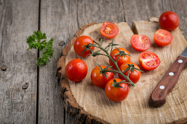 Tomatoes on a branch. Wooden background, rustic style. Copy space. - Foto, afbeelding