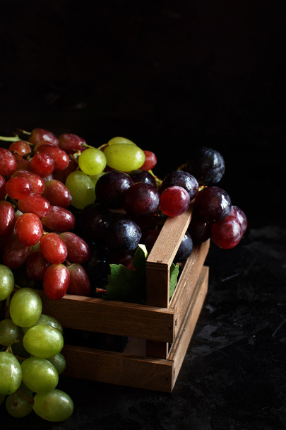 Tres tipos de uvas sobre un fondo oscuro
 - Foto, Imagen