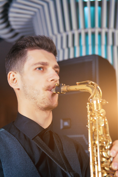 Młody mężczyzna gra na saksofonie instrument muzyczny - Zdjęcie, obraz