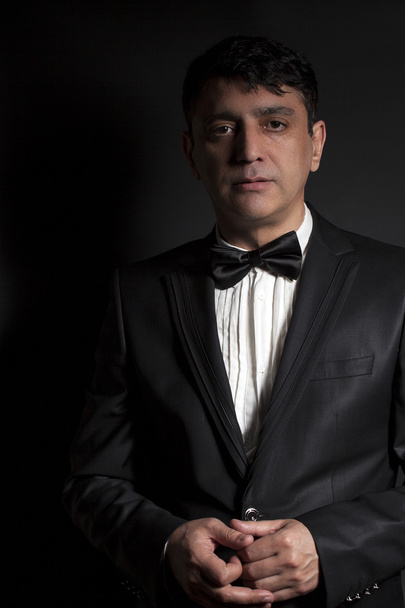 Elegant man wearing black bow tie and black suit - Fotografie, Obrázek