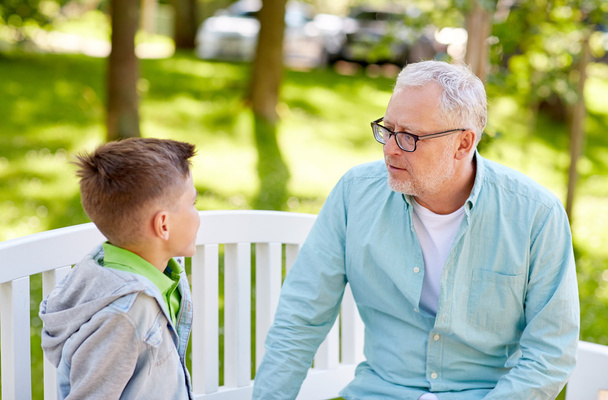 дід і онук розмовляють в літньому парку
 - Фото, зображення
