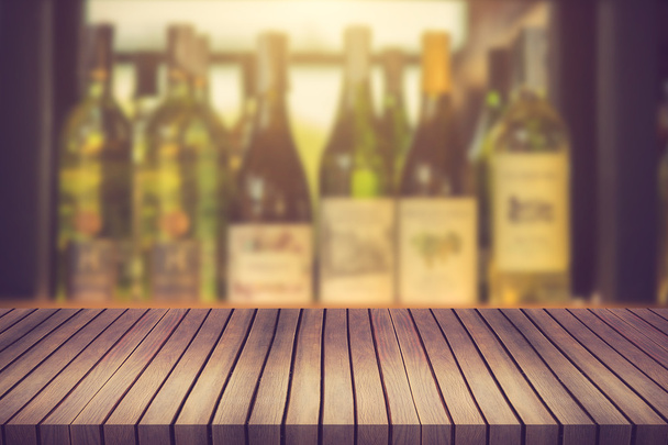 Mesa de madeira e garrafa de vinho Licor na prateleira Fundo borrado ca
 - Foto, Imagem