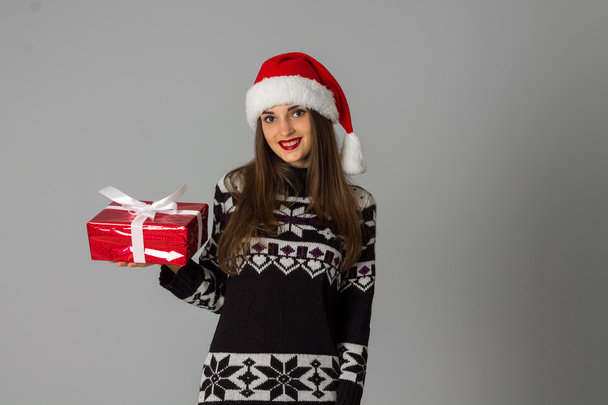 woman in warm sweater and santa hat with red gift - Photo, image