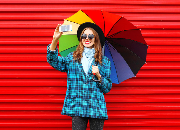 Fashion pretty young smiling woman with colorful umbrella taking - Foto, Imagem