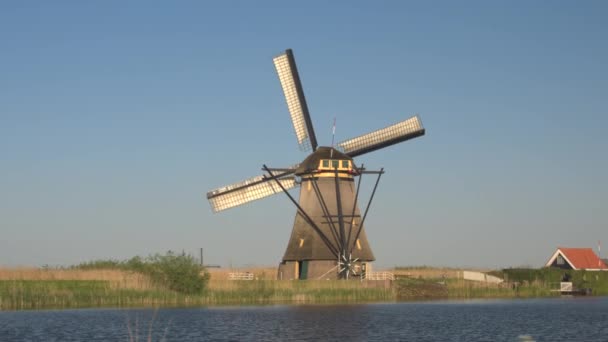 landschap met draaiende windmolen langs kanaal - Video