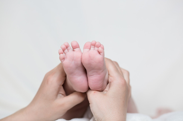 τα πόδια του μωρού στα χέρια της μητέρας - Φωτογραφία, εικόνα