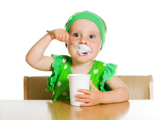 girl eats with a spoon dairy product. - Foto, Imagem
