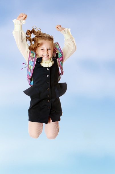 Mädchen Schulmädchen mit Schulranzen hinter den Schultern springt - Foto, Bild