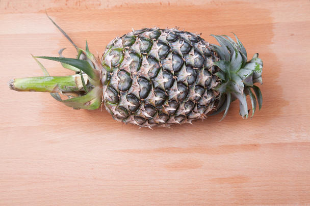 Pineapple on wooden table - Φωτογραφία, εικόνα