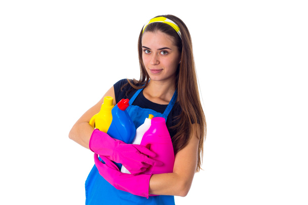 Vrouw in schort een detergentia te houden - Foto, afbeelding