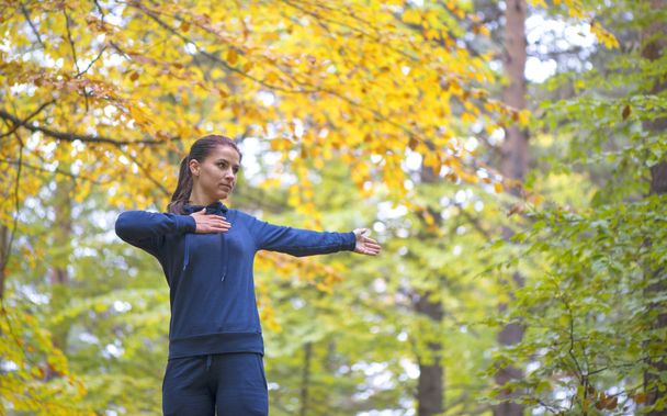 Energetic young woman do exercises outdoors in park to keep their bodies in shape - Photo, Image