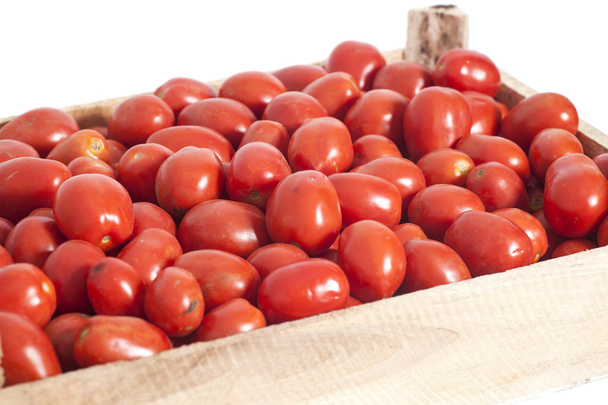 Ripe red tomatoes in wooden box isolated on white - Foto, afbeelding