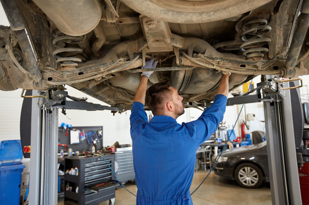 mechanic man or smith repairing car at workshop - Foto, Bild
