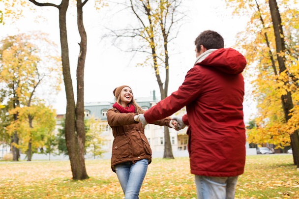 feliz pareja joven divirtiéndose en el parque de otoño
 - Foto, Imagen