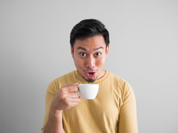 Asian man drinks coffee. - Zdjęcie, obraz