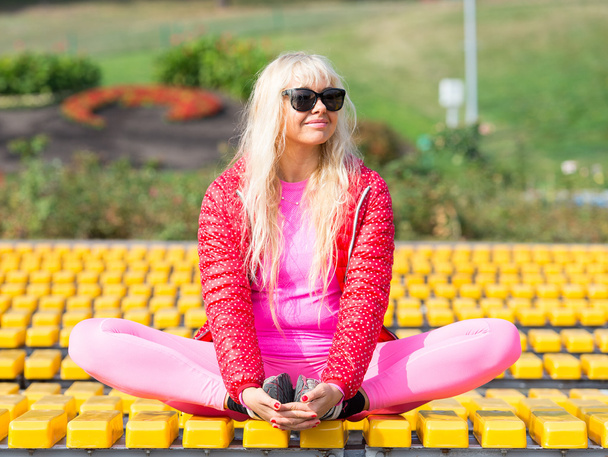 Pretty young woman doing yoga asanas in the park - Фото, зображення