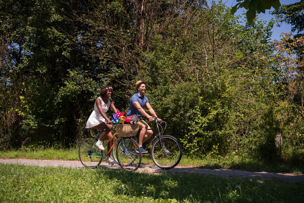 Молода багатоетнічна пара катається на велосипеді в природі
 - Фото, зображення
