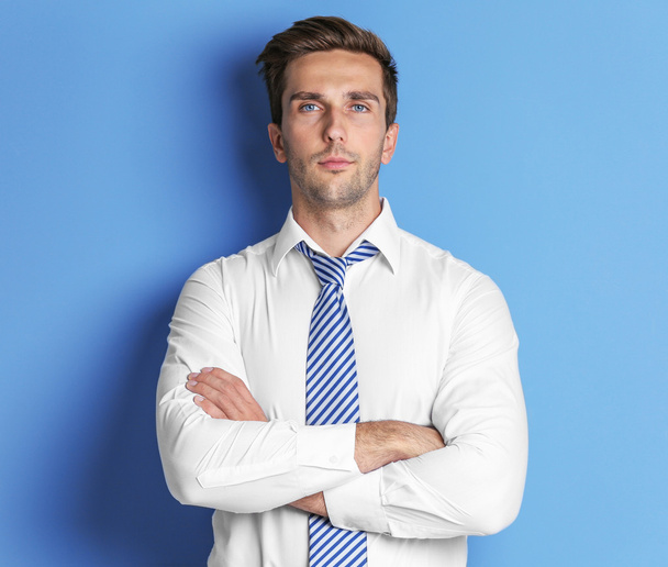 Young happy businessman on blue background - Foto, afbeelding