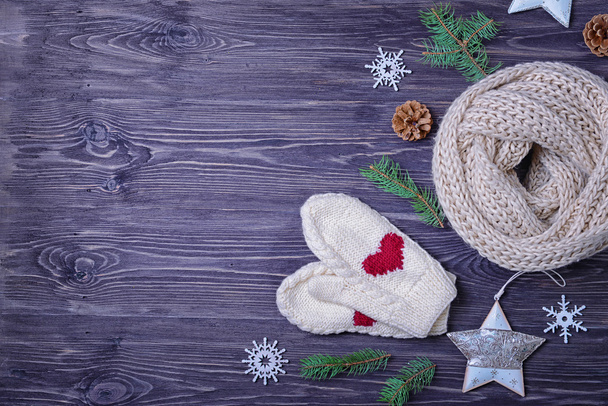 Knitted scarf, mittens and Christmas decor on wooden background - Photo, image