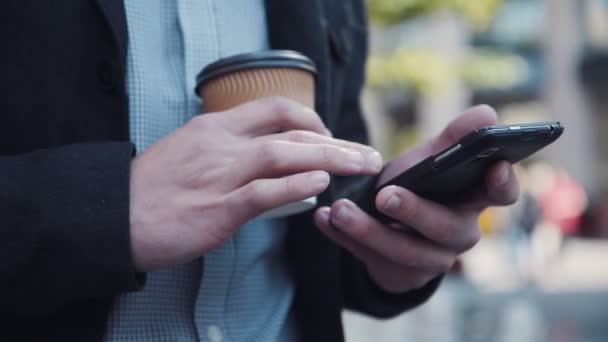 Wysyłanie SMS-ów człowiek z filiżanką kawy w ręku - Materiał filmowy, wideo