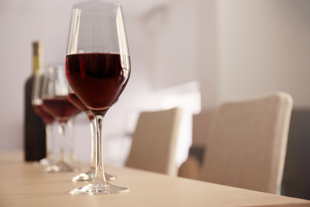 Glasses of red wine on table in restaurant - Фото, изображение