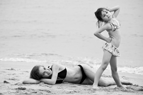 Femme et petite fille se détendre sur la plage
  - Photo, image