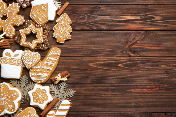 Tasty gingerbread cookies and Christmas decor on wooden background - Fotoğraf, Görsel