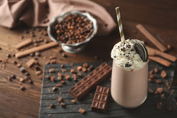 Delicious creamy milkshake with cookie on wooden background - Zdjęcie, obraz